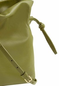 Olivengrüne Leder-Schultertasche mit zerknittertem Design, verstellbarem Schulterriemen und goldenen Hardware-Akzenten. Glatte Textur auf der Oberfläche.