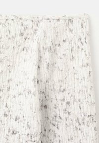 Valkoinen teksturoitu kangas, jossa on harmaita marmorointeja, näyttäen ryppyiseltä ja kevyeltä. Rakenne reunat näkyvät.