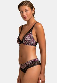 Bralette avec dentelle et culottes assorties présentant un imprimé floral en violet, rose et noir. Tissu doux avec bretelles ajustables.