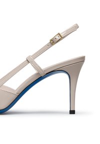 Sandal in pelle beige con tacco alto, suola con accento blu, cinturino regolabile con fibbia e design elegante a stiletto. Finitura lucida e punta aperta.