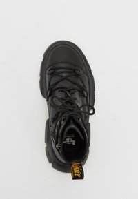 Black lace-up boot with a textured leather upper, round toe, thick black rubber sole, and yellow pull tab at the heel.
