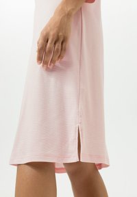 Vaaleanpunainen raidallinen mekko, jossa on sivuhalkio, sileä pinta ja löysä istuvuus. Mallissa on pyöreä pääntie ja lyhyet hihat.