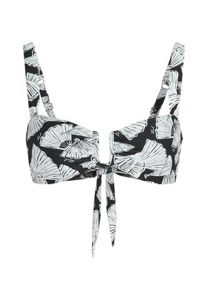 Mustmust kommid valge lehe mustriga, reguleeritavate rihmadega, ees köitmise sulgemisega ja keskel lõikega detailiga.