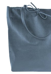 Zwarte leren tote bag met een gestructureerd oppervlak, voorzien van twee handvatten en een gestrikt sluiting aan de bovenkant. Eenvoudig, hoekig ontwerp.