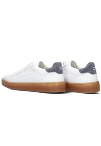 Witte leren sneakers met grijze suede hielaccenten, platte gumrubberen zool, vetersluiting en minimalistisch ontwerp.