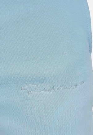 Un tissu bleu clair présentant une finition lisse et légèrement texturée, avec un logo brodé de couleur contrastante sur la surface visible.