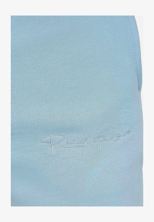 Un tissu bleu clair présentant une finition lisse et légèrement texturée, avec un logo brodé de couleur contrastante sur la surface visible.