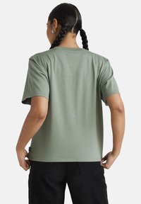 Short-sleeve, crew-neck T-shirt in olive green cotton. Features a relaxed fit and a small label at the left side seam.