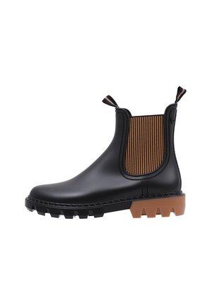 Bottillon en caoutchouc noir avec panneau latéral élastique rayé marron, languettes de tirage et semelle robuste beige ; conception imperméable et construction solide.