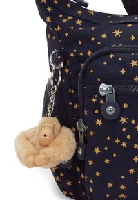 Bolso marino con patrón de estrellas doradas, que incluye un llavero de mono de peluche. Cuenta con bolsillos con cremallera y acentos metálicos. Tejido texturado.