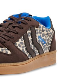 Brązowe zamszowe trampki z panelami w panterkę, niebieskim wnętrzem i czarnymi paskami. Posiadają gumową podeszwę i teksturowane wykończenie.