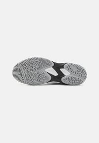 Black athletic shoe sole with a textured grey rubber surface, featuring a patterned tread for grip and stability.