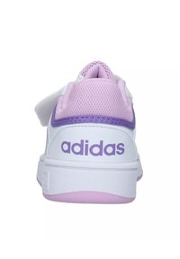 Sneaker bianca con accenti viola e rosa, caratterizzata da una tomaia in rete, collare imbottito e logo sul tallone. Suola spessa in gomma per supporto.