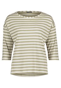 Randig topp i ljus beige och olivgrön, med en vid halsringning och trekvartsärmar, med en lätt krökt fåll och subtil textdetalj.