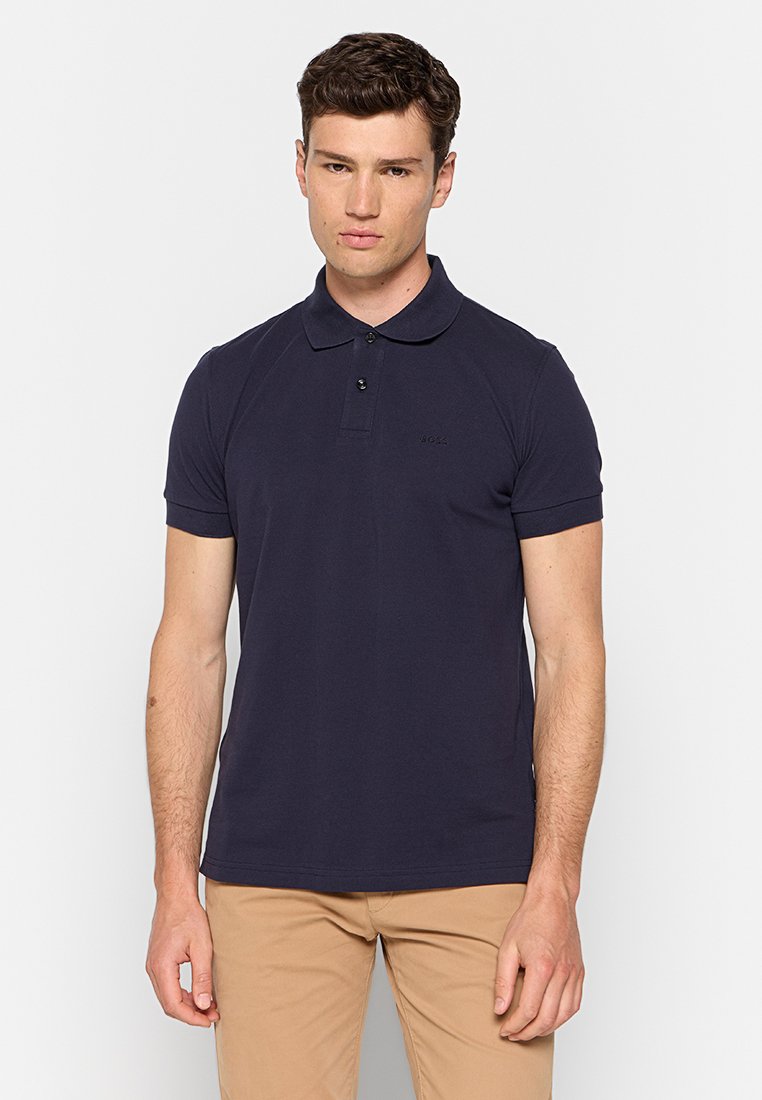 Polo shirt blu navy in cotone, con colletto a tre bottoni, maniche corte e un logo sottile sul petto. Texture liscia.