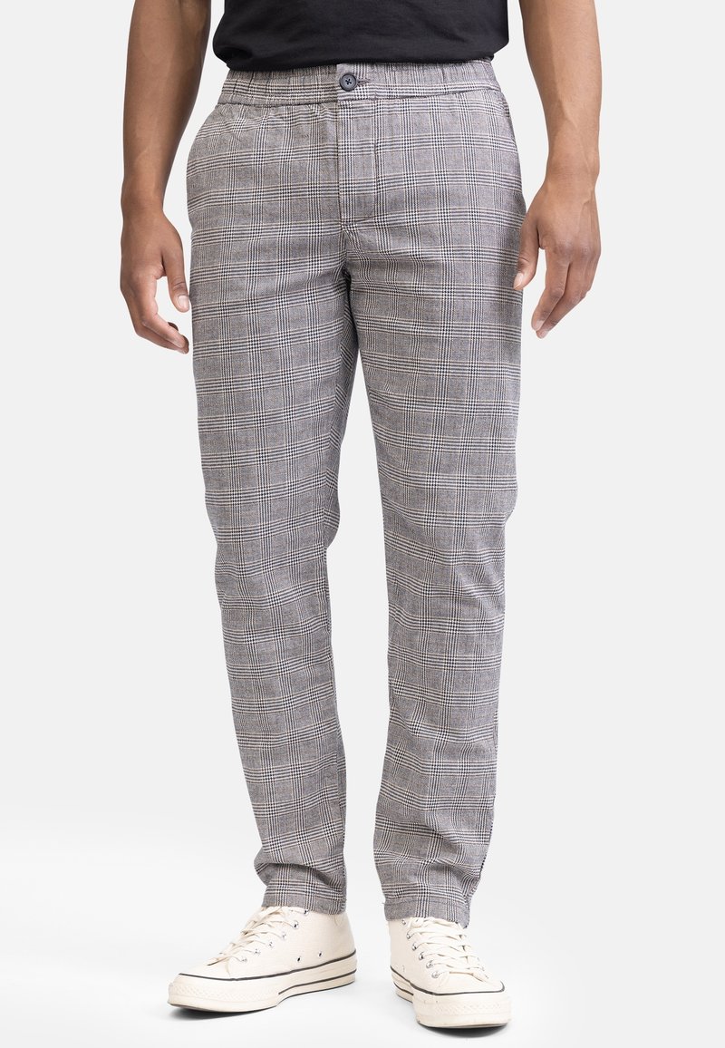 Gray plaid trousers with a relaxed fit, featuring a button closure and side pockets. Paired with white sneakers for a casual look.