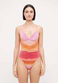 Maillot de bain une pièce en dégradé de rose, orange et rouge, avec un décolleté en V, des détails froncés, des bretelles fines et un design de jambe échancrée.