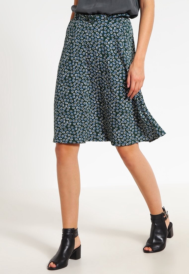 Kukkakuosisukien tummanvihreä, jossa on valkoisia ja sinisiä kukkia. A-linjainen malli, keskipitkä, kevyestä kankaasta valmistettu.