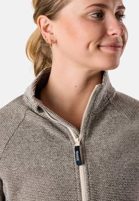 Giacca grigia con zip, dal design testurizzato e a coste, con colletto alto e zip di colore crema a contrasto. Accentuata da un piccolo etichetta con logo.