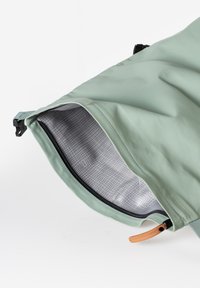 Borsa impermeabile verde con un interno a quadri grigi testurizzati. Presenta una chiusura superiore con zip e un accento in pelle beige per una presa facile.