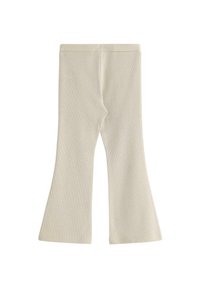 Beżowe legginsy w prążki z rozkloszowanym dołem. Materiał wydaje się być miękki z teksturowanym wykończeniem, zapewniając dopasowany krój.