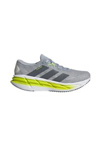 Zapatilla de running gris claro con parte superior de malla texturizada, acentos verdes y tres rayas grises. Presenta una suela amortiguadora con un detalle amarillo.