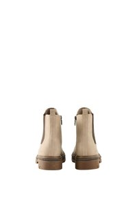 Bottes de cheville beige avec des panneaux élastiques latéraux et des fermetures éclair à l'arrière. Fini en cuir lisse, semelles en caoutchouc texturé et hauteur de talon modérée.