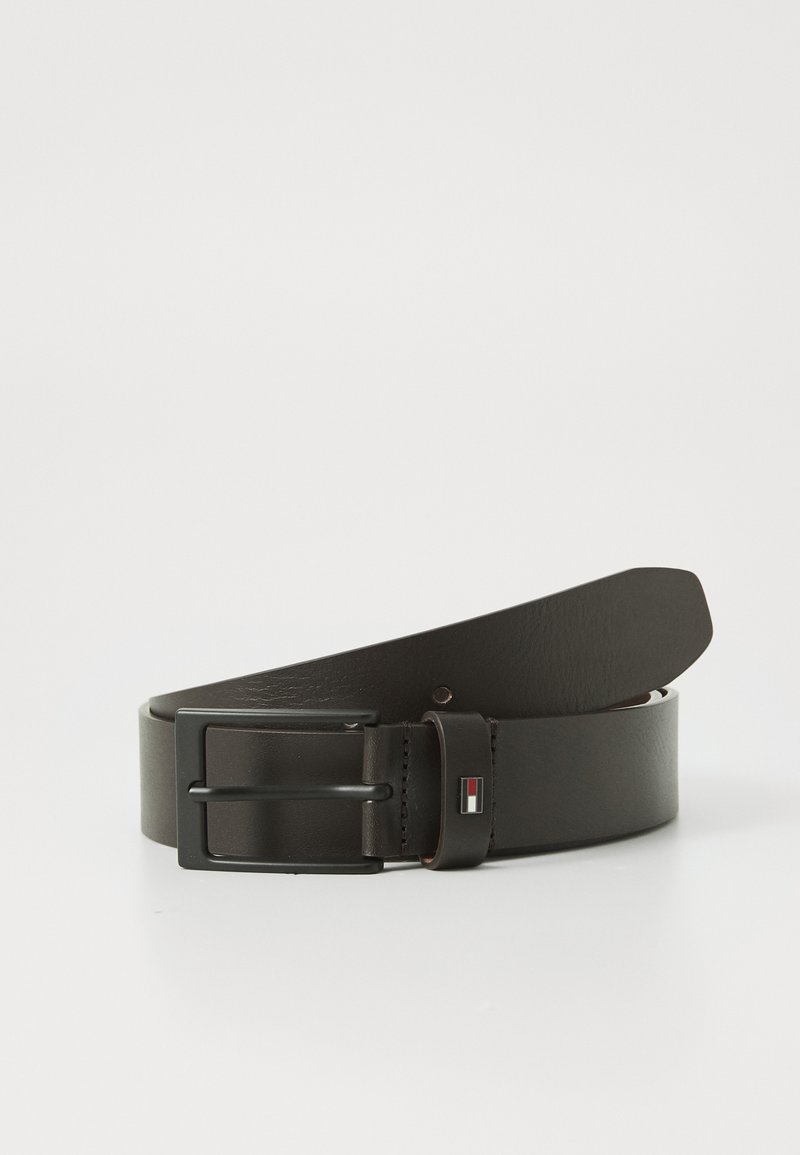 Cinturón de cuero marrón con una hebilla rectangular de metal negro y un pequeño detalle de logo en rojo, blanco y azul en el lazo de cuero.