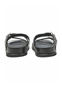 Svarta sandaler med platt sula, med korsade läderremmar och en silverfärgad spänne som accent. Slät textur och minimalistisk design.