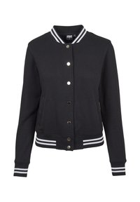 Svart atletisk jacka med vitrandig ribbad krage, ärmar och midja. Har tryckknappsstängning och sidofickor. Mjuk tygtextur.