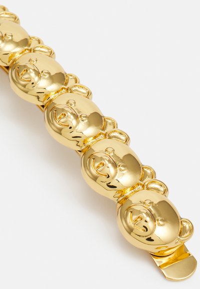 Zlata zapestnica v obliki medveda z sijočo površino, ki vsebuje več glav medvedov v zaporednem dizajnu in ravnim ježkom za zapiranje.