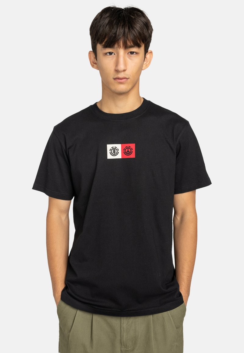Zwart katoenen T-shirt met een grafische print van twee ronde emblemen in het wit en rood op de borst. Korte mouwen en een ronde hals.