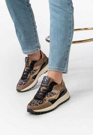 Le sneaker presentano un mix di suede marrone e nero con stampa leopardata, una suola spessa e un'etichetta con logo sulla linguetta.