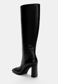 Czarne skórzane buty za kolano z wydłużonym noskiem, na słupkowym obcasie, o eleganckim designie i gładkiej teksturze. Brak widocznych elementów metalowych lub wzorów.