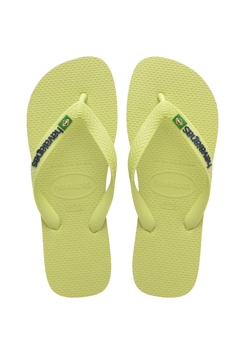 Šviesiai žali guminiu flip-flopu, su tekstūruotu padu, Y formos diržais ir „Havaianas“ prekės ženklu. Brazilijos vėliavos detalė kairiajame dirže.