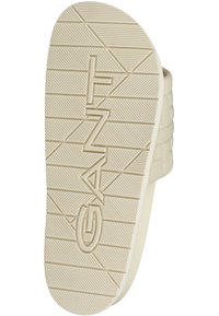 Beige sandalsål med tekstureret grebmønster og præget 'GANT' logo. Blødt materiale; let buet facon; minimalistisk design.