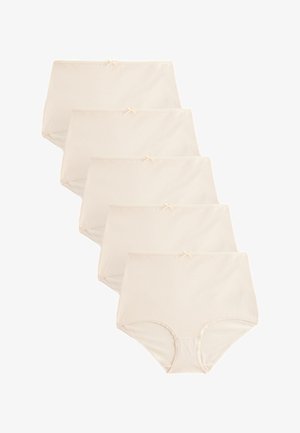 Nő hátulról, bézs magas derekú fehérneműt és hozzáillő melltartót visel, hosszú barna hajjal, kezét a csípőjén pihentetve.