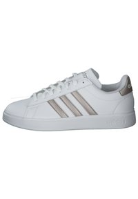 Witte sportieve schoen van synthetisch materiaal met drie beige strepen. Platte rubberen zool, afgeronde neus en vetersluiting aan de voorkant. Klassieke stijl.