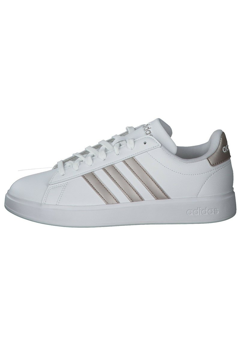 Witte sportieve schoen van synthetisch materiaal met drie beige strepen. Platte rubberen zool, afgeronde neus en vetersluiting aan de voorkant. Klassieke stijl.