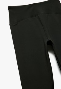 Svarta leggings i elastiskt material, med en bred midja och slät yta, samt platta sömmar för komfort och hållbarhet.