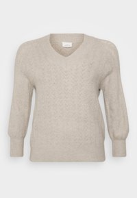 Beige strikket genser med V-hals, med et teksturert chevronmønster, lange ermer og ribbestrikkede mansjetter og kant. Lett materiale.