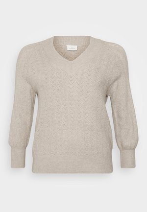 Jersey de punto beige con cuello en V, que presenta un patrón de chevrón texturizado, mangas largas y puños y bajo acanalados. Tela ligera.