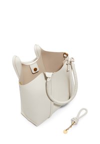 Sac fourre-tout en cuir blanc avec une texture lisse, doté de poignées doubles, d'un intérieur beige contrastant et d'une sangle amovible nouée avec un accent en or.