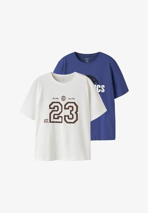 T-shirt blanc avec un grand "23" et du texte, superposé sur un t-shirt bleu avec un globe partiellement visible et un design de texte.