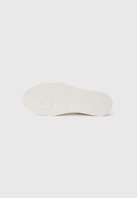 Lysfarvet gummisål med en glat overflade; har cirkulære og rektangulære mønstre for bedre greb; minimal branding synlig.