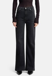 Zwart denim jeans met hoge taille en een wijd uitgesneden pijp, voorzien van een klassiek ontwerp met vijf zakken en metalen knoopdetails.