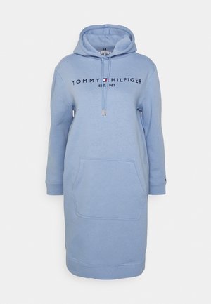 Jasnoniebieska długa sukienka z kapturem, kieszenią na przodzie, ściągaczem przy kapturze oraz logo "Tommy Hilfiger Est. 1985" na piersi.