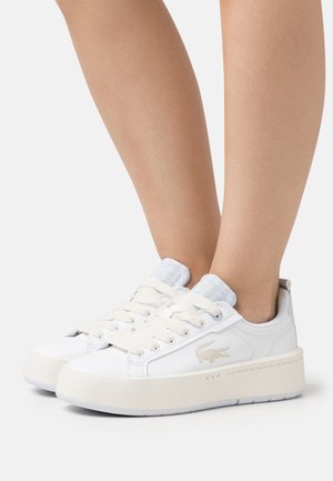 Zapatillas blancas con un material suave, lengüeta texturizada en contraste, suela gruesa color crema y cordones beige. Presenta un pequeño logo en el lateral.