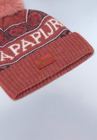Berretto lavorato a maglia di colore ruggine con un motivo a logo lavorato, sormontato da un pom-pom in pelliccia rosa removibile e dotato di una patch a bandiera sul polsino.