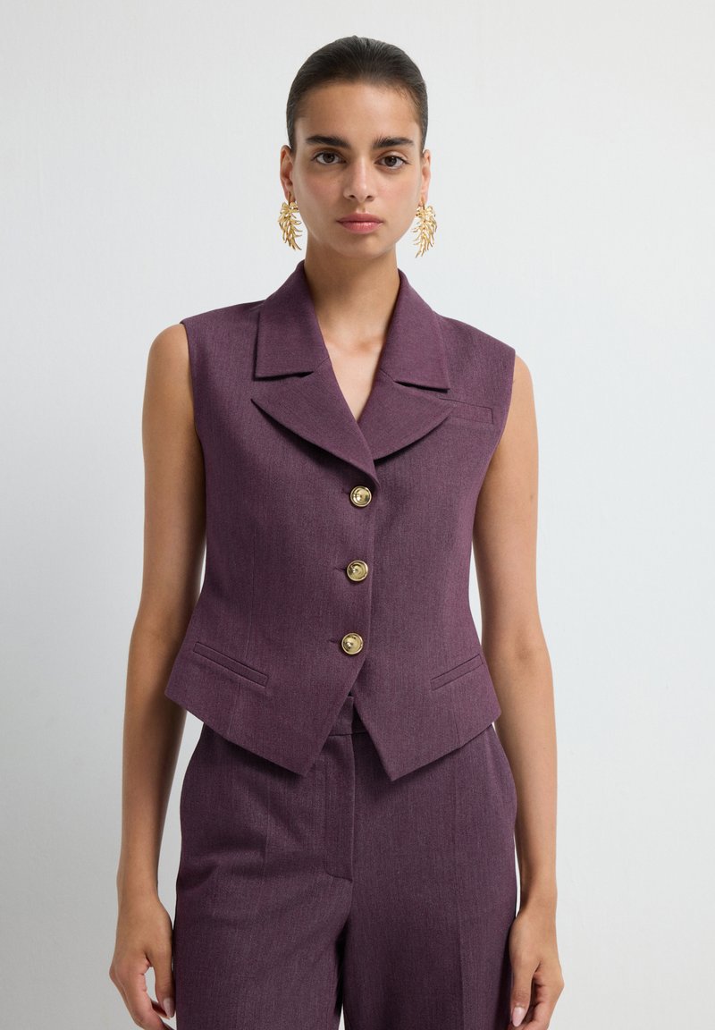 Sleeveless purple vest with a notched collar, five golden buttons, and two front pockets, made of textured fabric.